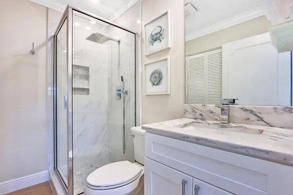 a bathroom with a sink a toilet and shower