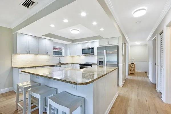 a large kitchen with stainless steel appliances kitchen island granite countertop a large counter top stainless steel appliances and cabinets