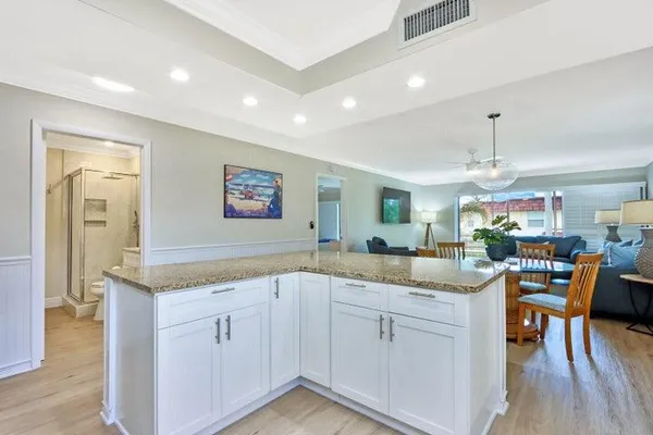 a kitchen with white cabinets and sink