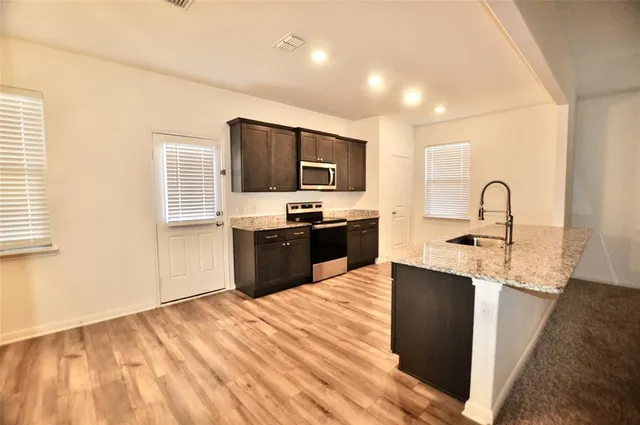 a kitchen with granite countertop a stove top oven and sink
