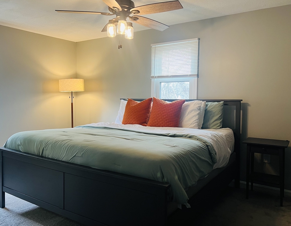 35 Pearl Street, Unit 35 Randolph, MA 02368 - Photo 24 of 31 a bedroom with a bed and a chandelier