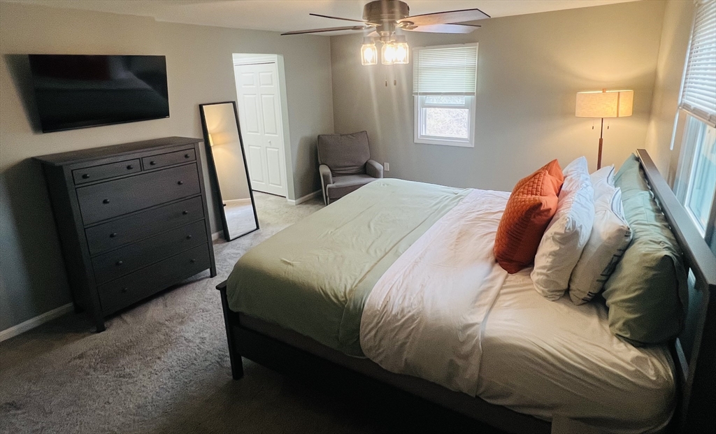 35 Pearl Street, Unit 35 Randolph, MA 02368 - Photo 26 of 31 a bedroom with a bed and a flat screen tv