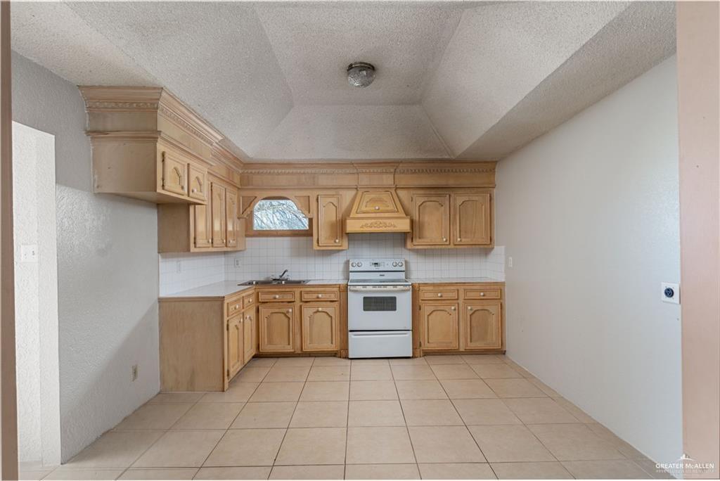 933 East 4th Street Roma, TX 78584 - Photo 5 of 15 a large kitchen with cabinets and stainless steel appliances