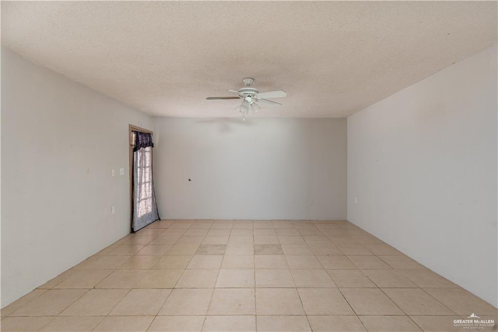 933 East 4th Street Roma, TX 78584 - Photo 6 of 15 an empty room with a ceiling fan and carpet