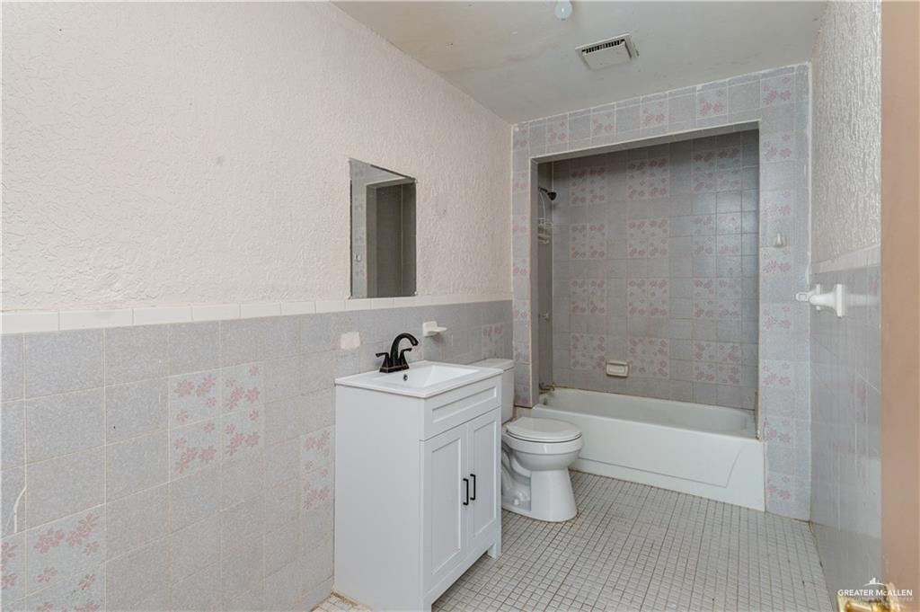 933 East 4th Street Roma, TX 78584 - Photo 9 of 15 a bathroom with a toilet a sink and bathtub