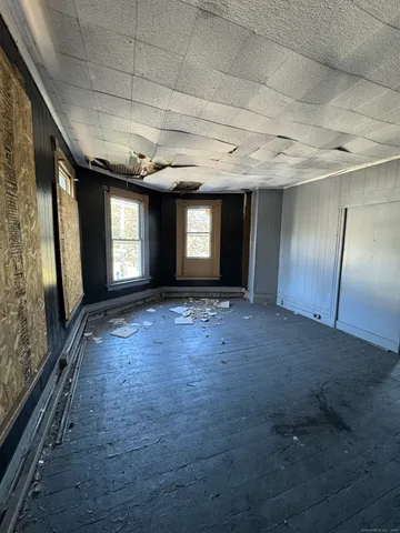 an empty room with windows and fan