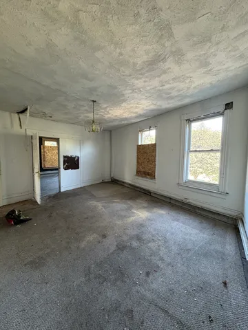 an empty room with a ceiling fan and window