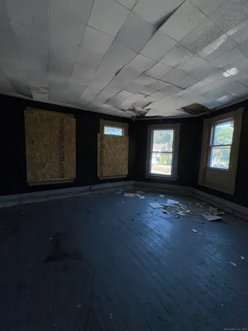 an empty room with windows and fireplace