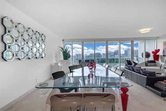 a kitchen with stainless steel appliances granite countertop a sink a stove a chimney a refrigerator and dining table