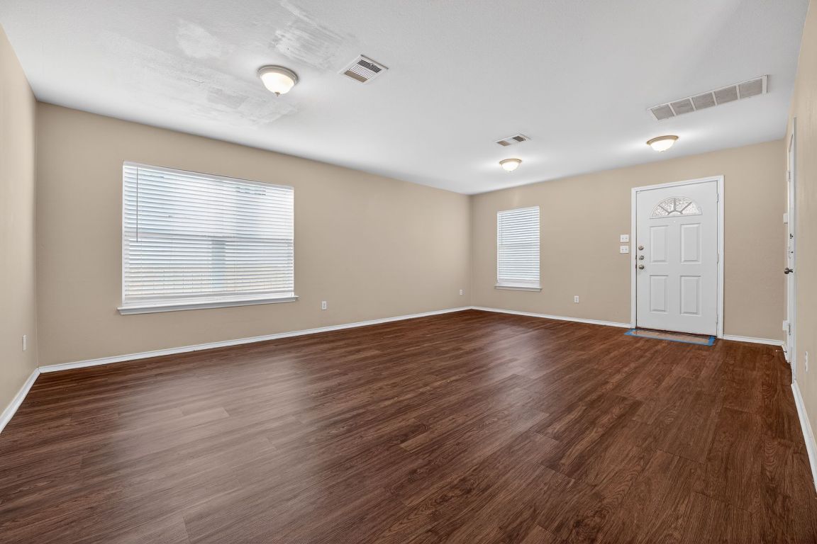 13205 Vizquel Loop Del Valle, TX 78617 - Photo 11 of 31 an empty room with wooden floor cabinet and windows