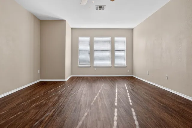a view of a room with wooden floor and ceiling fan