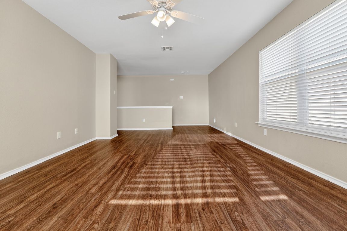 13205 Vizquel Loop Del Valle, TX 78617 - Photo 18 of 31 a view of a room with wooden floor and ceiling fan