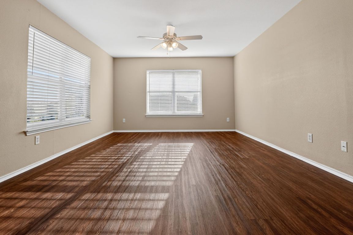13205 Vizquel Loop Del Valle, TX 78617 - Photo 19 of 31 a view of an empty room with wooden floor and a window