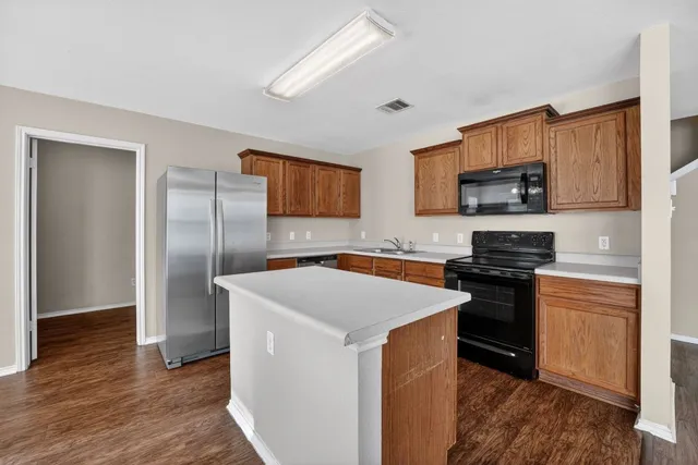 a kitchen with a refrigerator a stove top oven a sink and dishwasher
