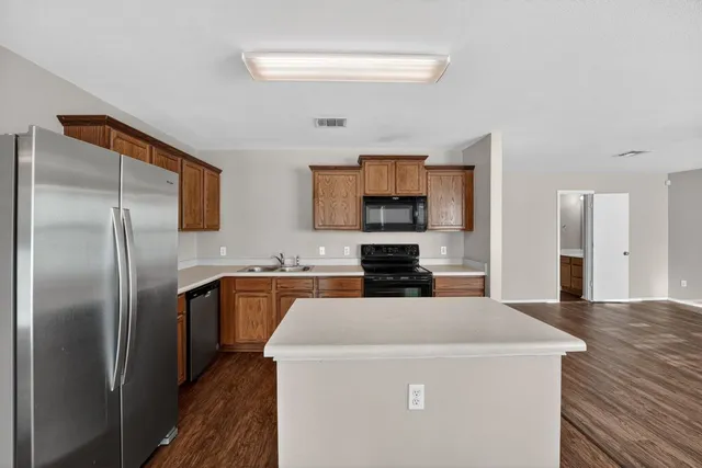 a kitchen with a stove sink and cabinets