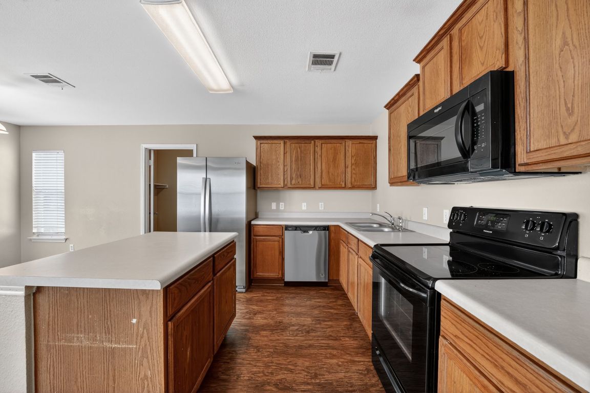 13205 Vizquel Loop Del Valle, TX 78617 - Photo 22 of 31 a kitchen with a stove sink and cabinets