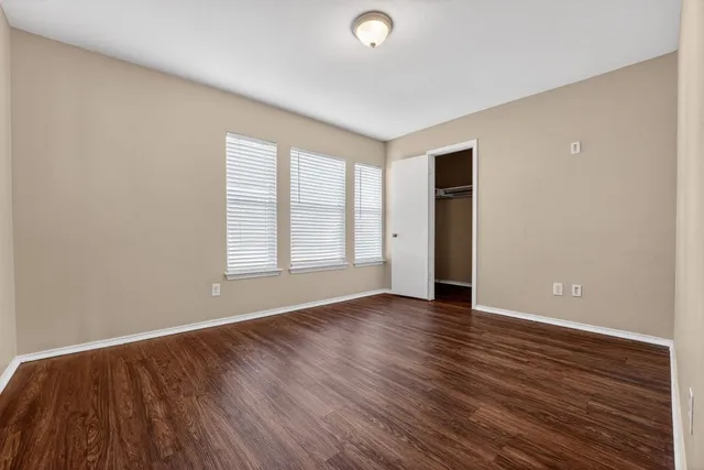 a view of empty room with wooden floor and ceiling fan