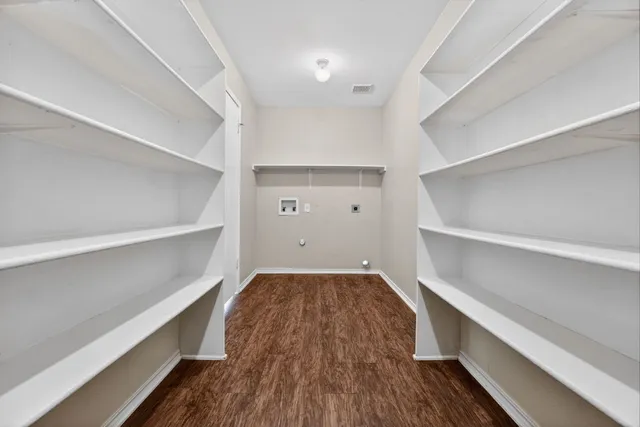 a view of walk in closet with wooden floor