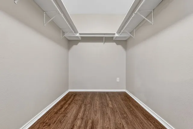 a view of walk in closet with empty racks