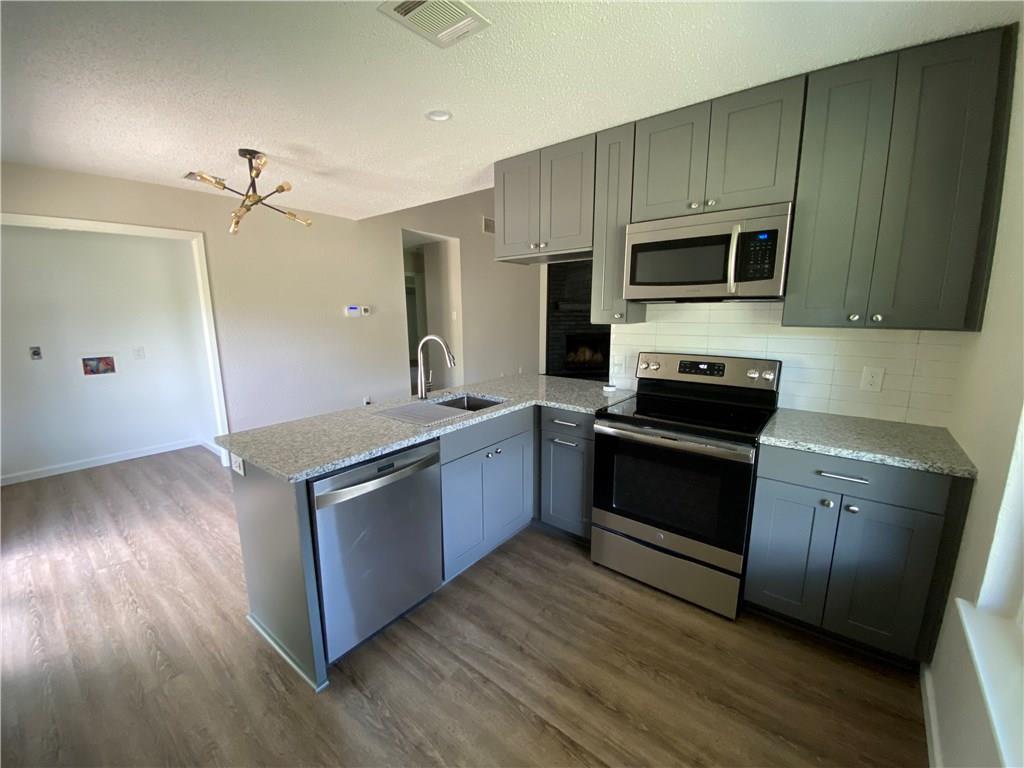 1715 Shadowview Drive, Unit B Austin, TX 78758 - Photo 18 of 28 A contemporary kitchen showcases sleek cabinetry, stone countertops, and modern stainless steel appliances.