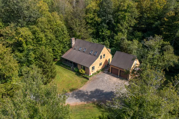 an aerial view of a house with swimming pool and sitting area