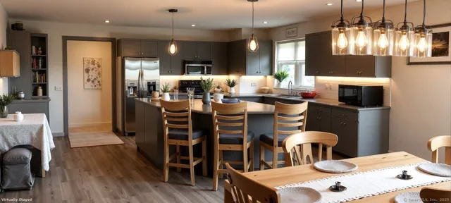 a kitchen with stainless steel appliances kitchen island granite countertop a dining table chairs and wooden floor