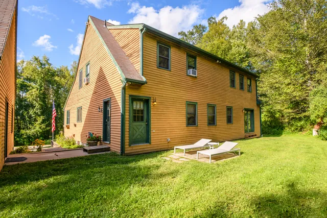 a backyard of a house with table and chairs
