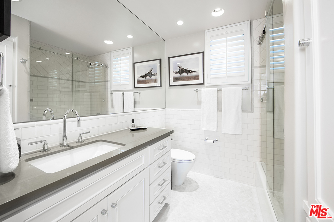1286 Coast Village Road Montecito, CA 93108 - Photo 19 of 23 a bathroom with a granite countertop sink a toilet a mirror and shower