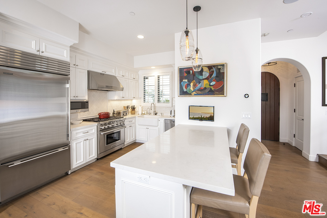 1286 Coast Village Road Montecito, CA 93108 - Photo 5 of 23 a kitchen with stainless steel appliances granite countertop a stove a refrigerator a oven a sink with a dining table and chairs