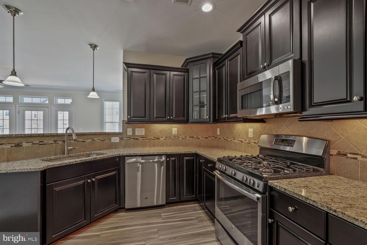 42550 Sunset Ridge Square Ashburn, VA 20148 - Photo 12 of 36 a kitchen with stainless steel appliances granite countertop a stove a sink and a microwave