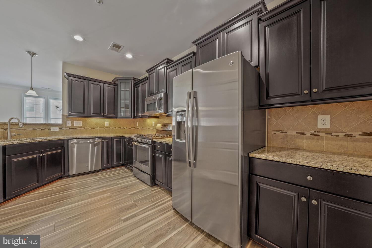 42550 Sunset Ridge Square Ashburn, VA 20148 - Photo 14 of 36 a kitchen with stainless steel appliances granite countertop a refrigerator and a stove top oven