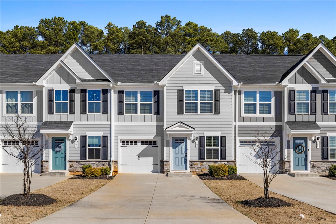 This charming townhouse features inviting entryways and convenient attached garages.