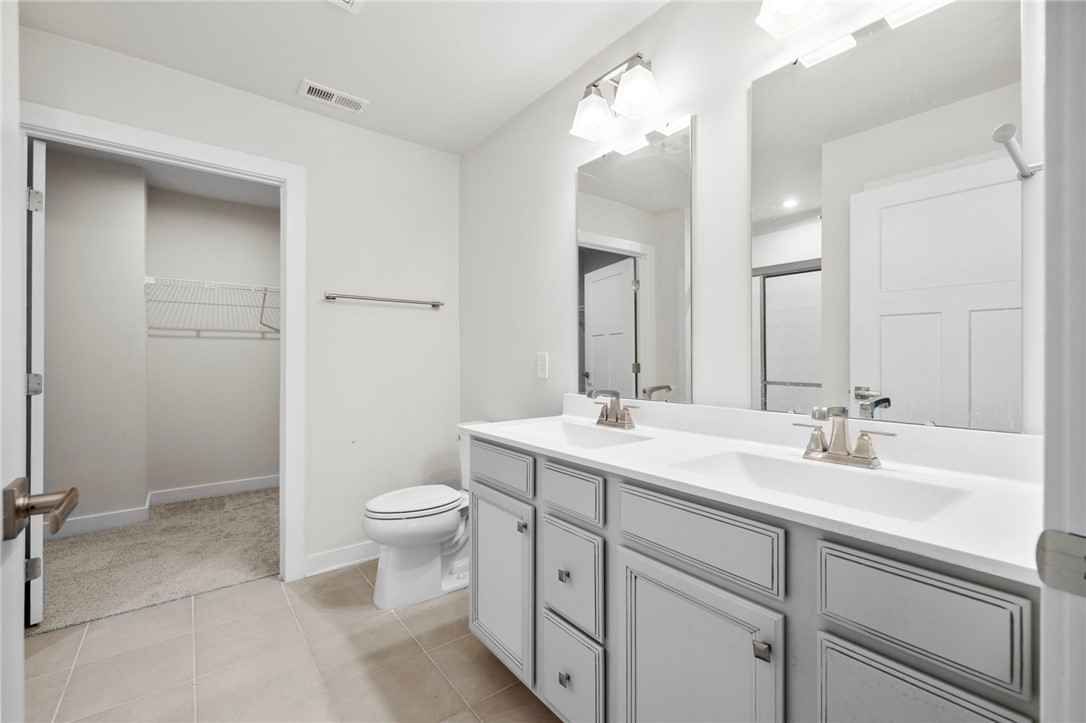 506 Roan Creek Trail Anderson, SC 29621 - Photo 16 of 33 This bright bathroom features a spacious dual vanity and convenient walk-in closet access.