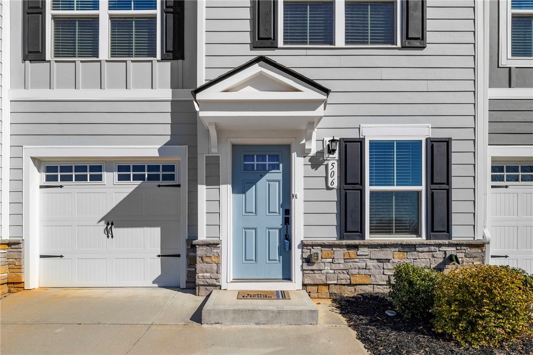 506 Roan Creek Trail Anderson, SC 29621 - Photo 2 of 33 This inviting home showcases a light blue front door, stone accents, and a classic garage.