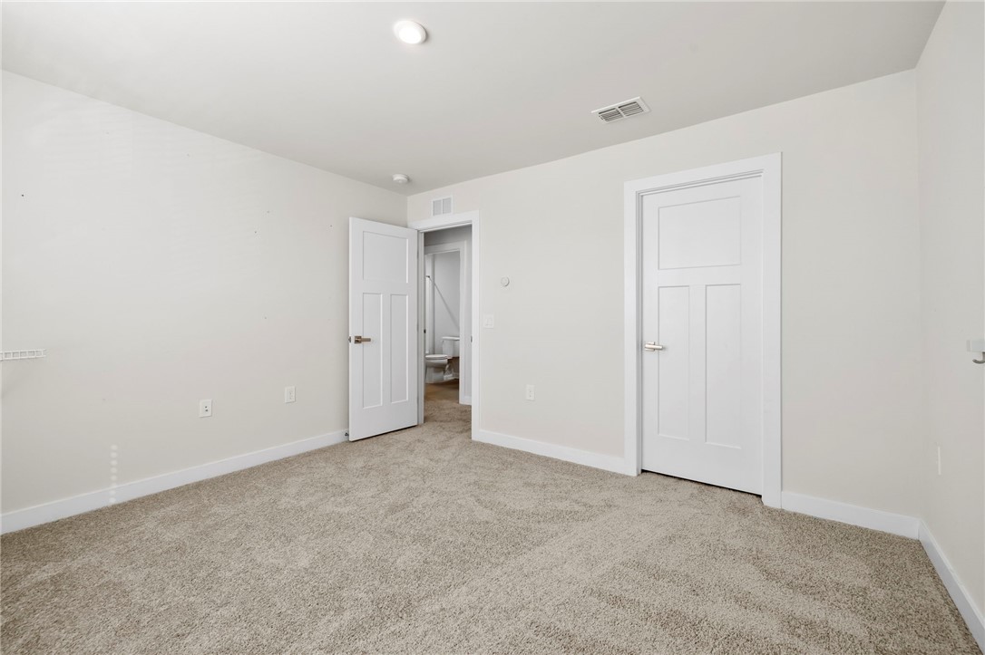506 Roan Creek Trail Anderson, SC 29621 - Photo 21 of 33 This inviting bedroom features soft carpeting, crisp white trim, and a clear view to the attached bathroom.