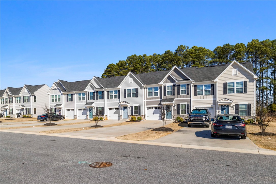 506 Roan Creek Trail Anderson, SC 29621 - Photo 3 of 33 These modern townhomes feature inviting exteriors, ample parking, and well-maintained grounds, creating a perfect neighborhood setting.