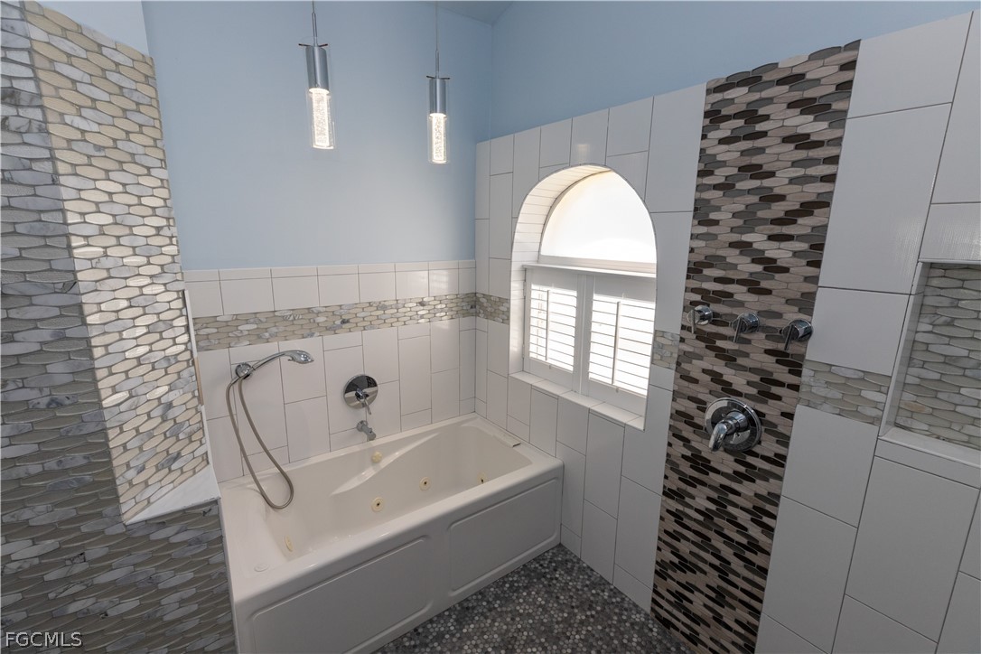 7500 Cameron Circle Fort Myers, FL 33912 - Photo 16 of 21 a bathroom with a bathtub a window and a shower