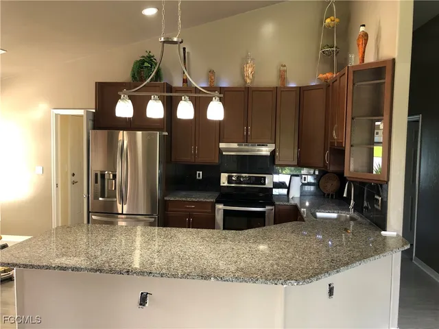 a kitchen with a refrigerator a stove and cabinets
