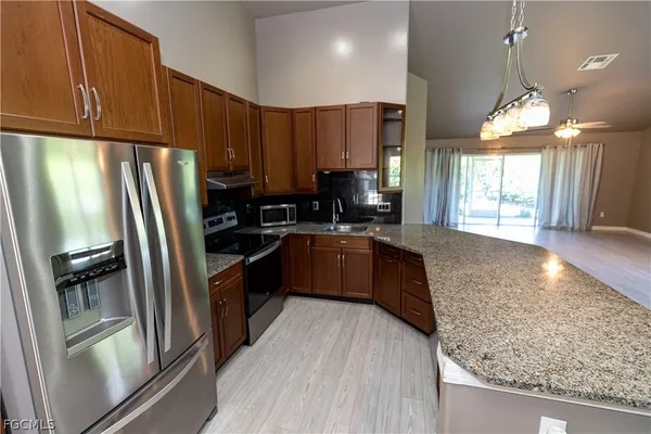 a kitchen with stainless steel appliances granite countertop wooden cabinets a stove a sink and a granite counter tops