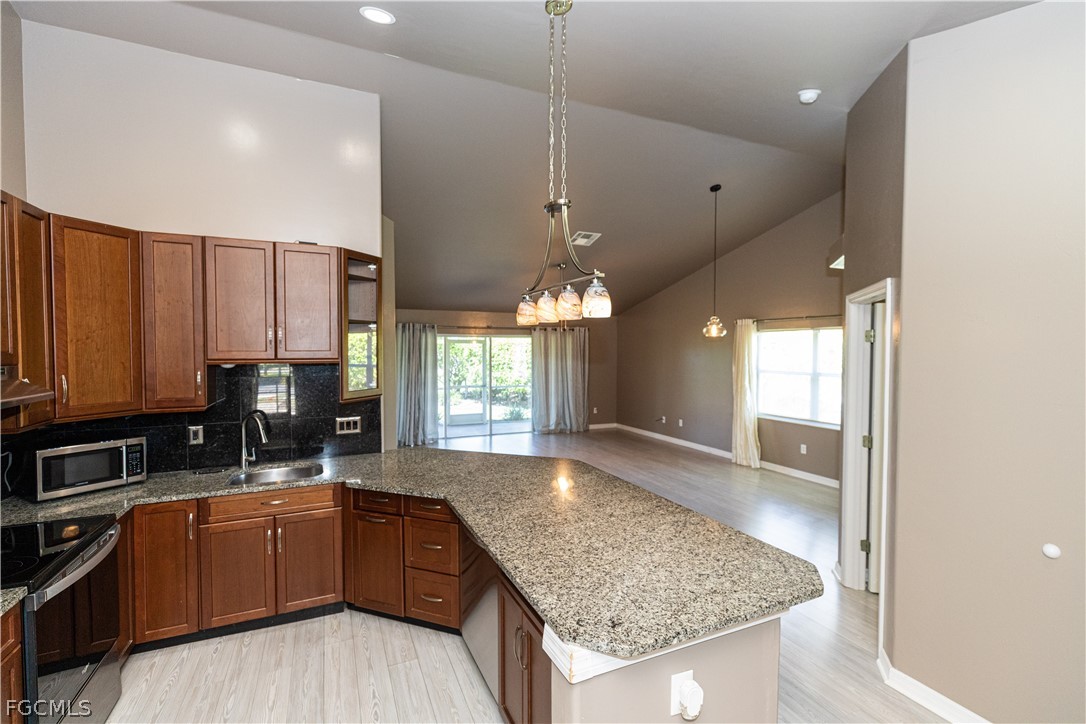 7500 Cameron Circle Fort Myers, FL 33912 - Photo 6 of 21 a kitchen with stainless steel appliances granite countertop wooden cabinets a stove a sink and a granite counter tops
