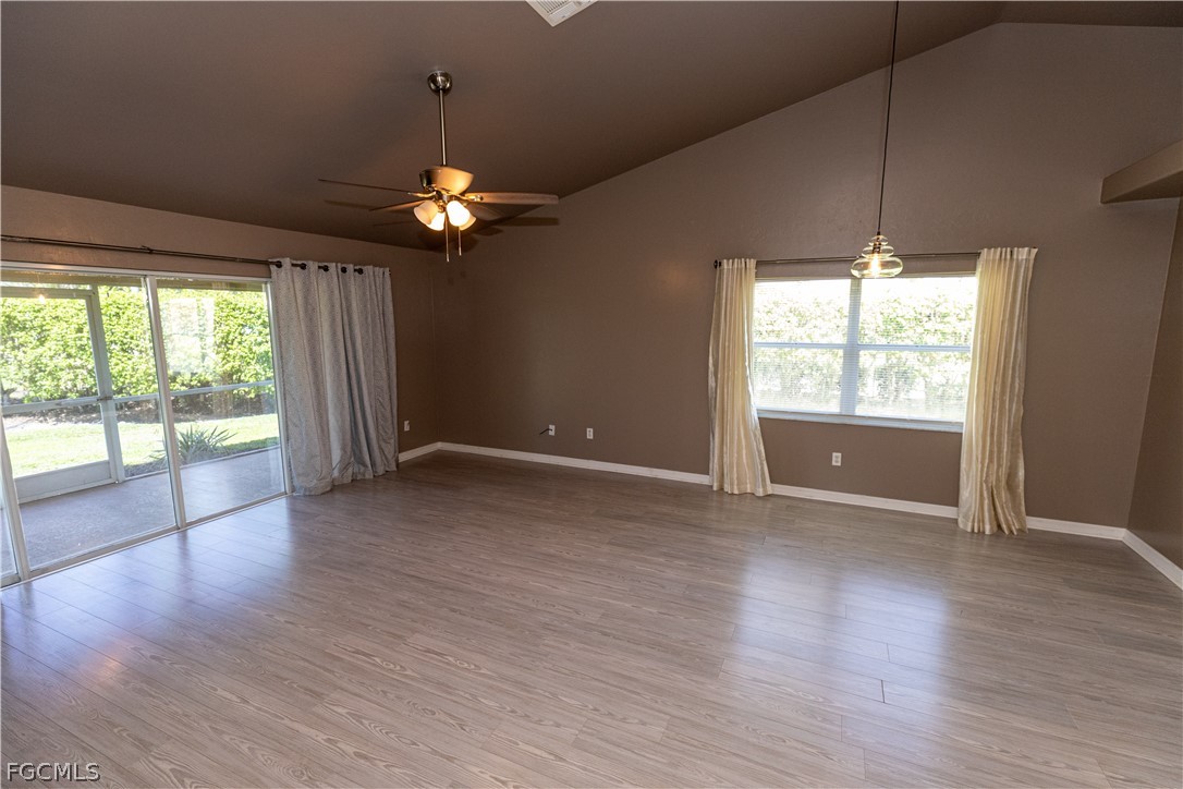 7500 Cameron Circle Fort Myers, FL 33912 - Photo 8 of 21 an empty room with wooden floor chandelier fan and windows