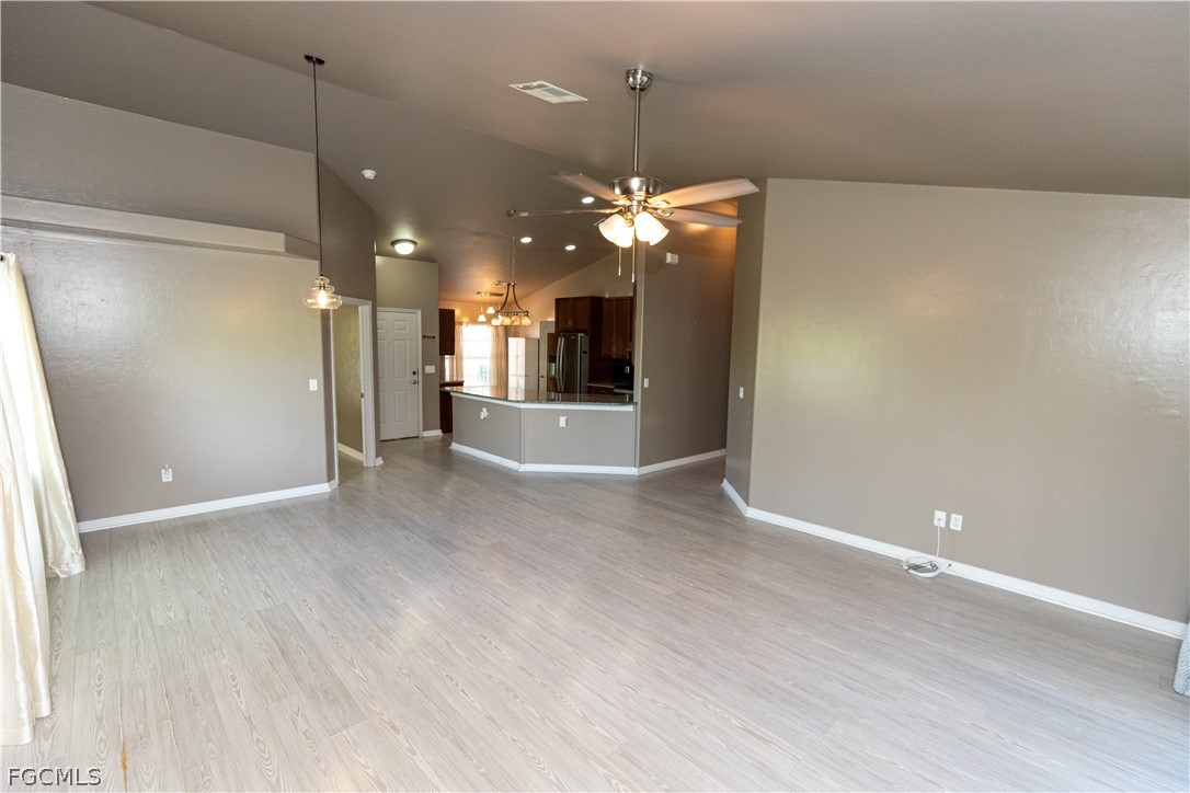 7500 Cameron Circle Fort Myers, FL 33912 - Photo 10 of 21 an empty room with chandelier fan and kitchen view