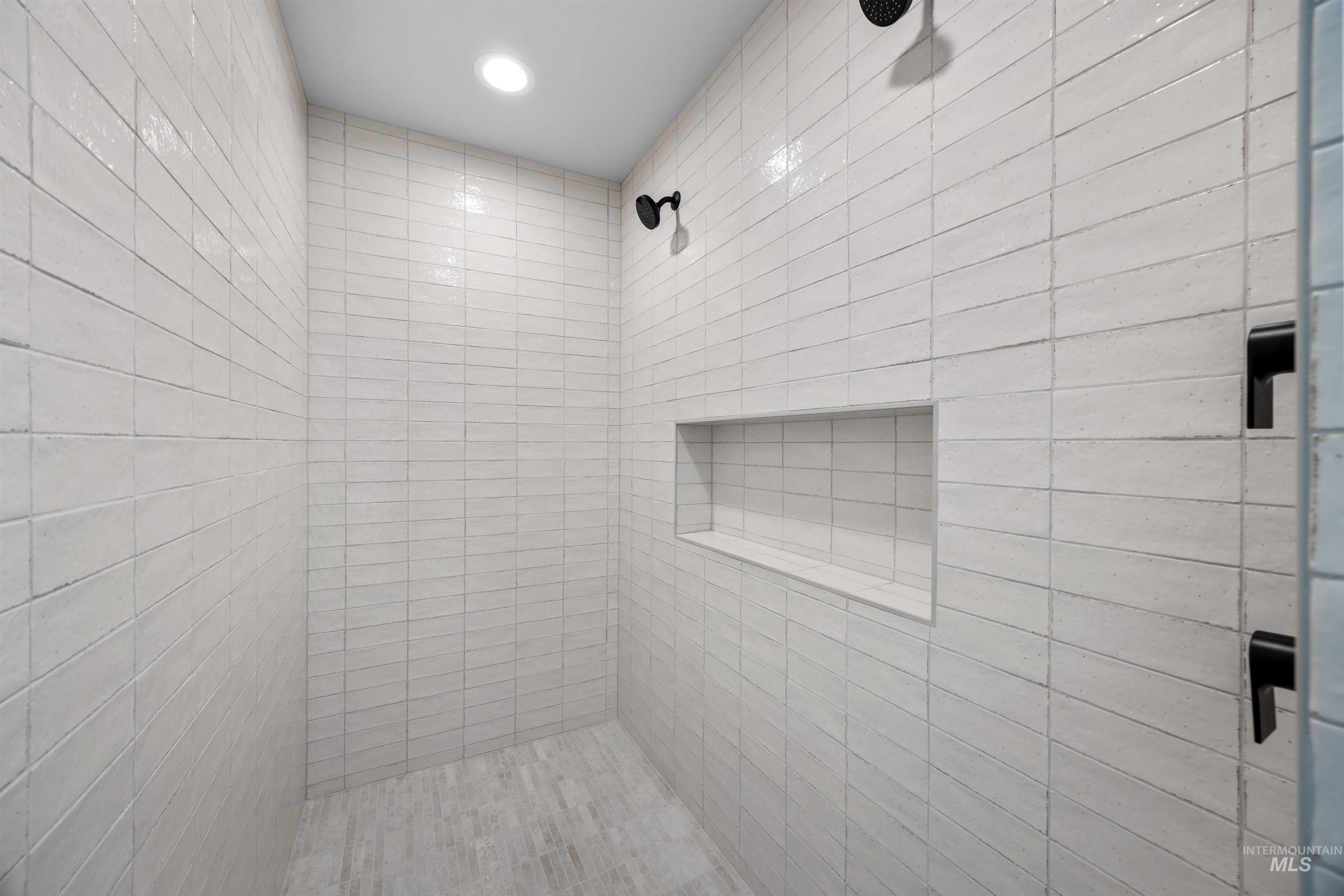 5940 South Pinpoint Way Meridian, ID 83642 - Photo 30 of 40 Tiled shower with matte black fixtures, an integrated niche, and recessed lighting