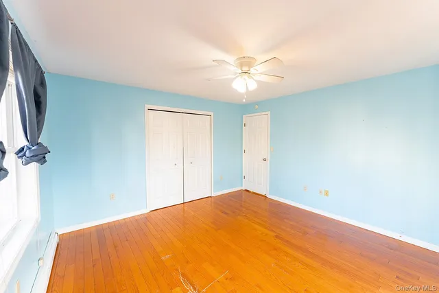 a view of a big room with a ceiling fan and a window