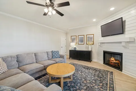 a living room with furniture a large window and a fireplace