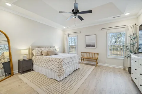a bedroom with a bed flat screen tv and a chandelier