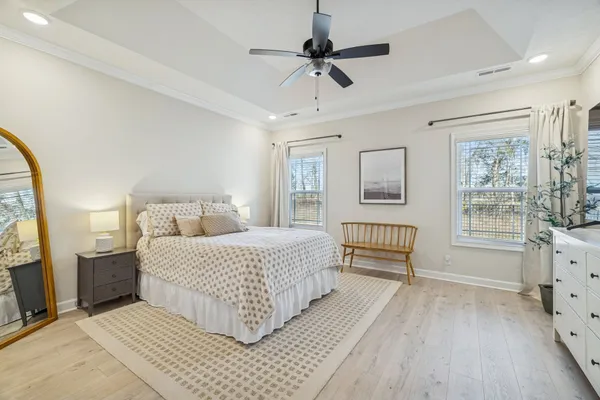 a bedroom with a large bed and a chandelier