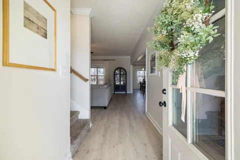 a kitchen with stainless steel appliances kitchen island granite countertop a refrigerator a stove microwave and a dining table with wooden floor