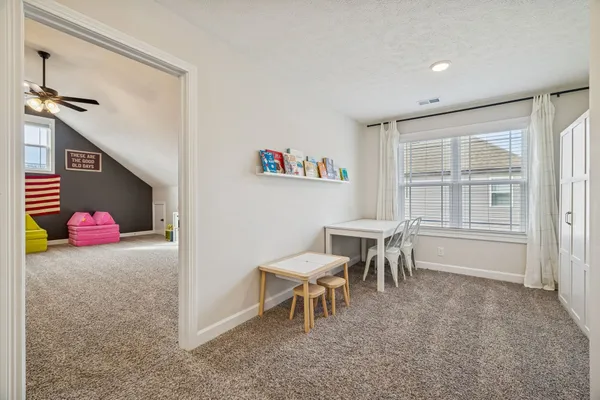 a bedroom with a bed a table and a window