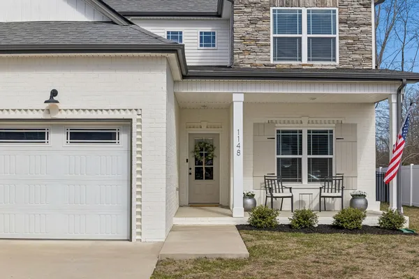 a kitchen with stainless steel appliances granite countertop a sink dishwasher a stove top oven a refrigerator with wooden cabinets and floor